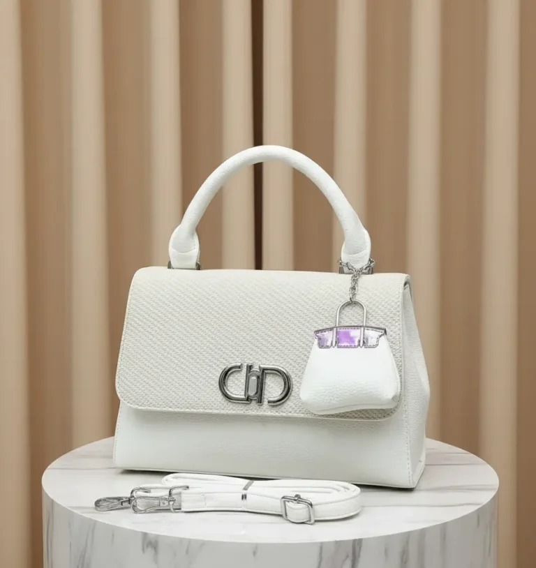 white cross body handbag with beautiful keychain and long strap